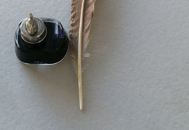 A quill and inkwell on paper